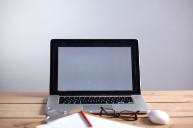 Laptop ahşap bir masada duruyor.