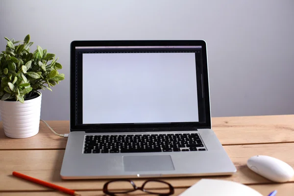 Laptop ahşap bir masada duruyor. — Stok fotoğraf