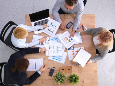 İş ortaklarının toplantıda belge ve fikirleri tartıştığı resim