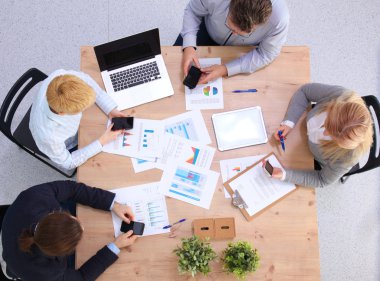 İş ortaklarının toplantıda belge ve fikirleri tartıştığı resim