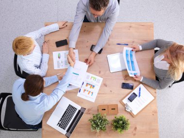 İş ortaklarının toplantıda belge ve fikirleri tartıştığı resim