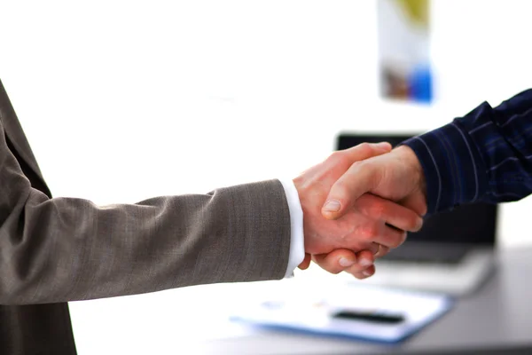 Business handshake. Two businessman shaking hands with each other in the office