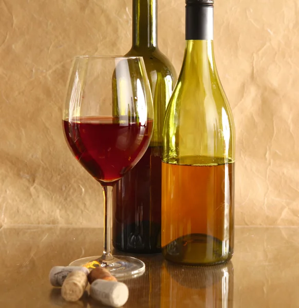 Botella de vino y copa de vino en una mesa de vidrio — Foto de Stock