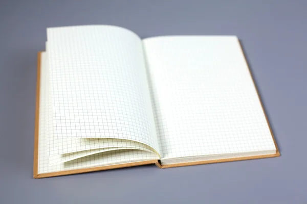 Open net note pad with a pen on a gray table — Stock Photo, Image