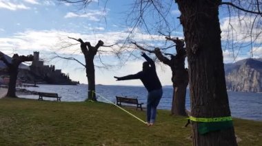 İtalya, Malcesine, ipte dengede yürüyor göle bakıyor, romantik ip cambazı