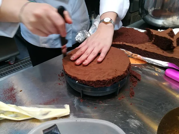 pastry chef prepares a chocolate cake, sponge cake