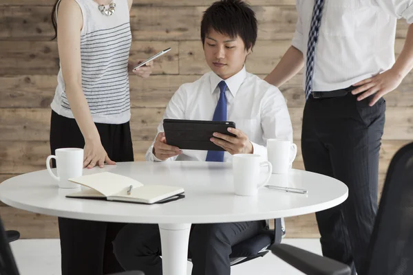 Imagen de tres personas de negocios usando tableta en la reunión —  Fotos de Stock