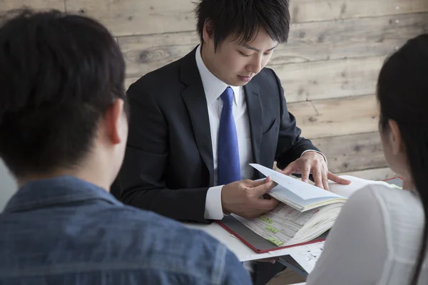 Real estate broker showing the project of the house to the family — Stock Photo, Image