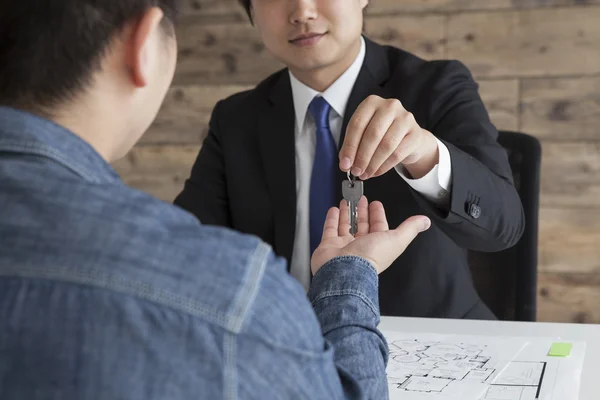 Real estate agent passing a key to man — Stock Photo, Image