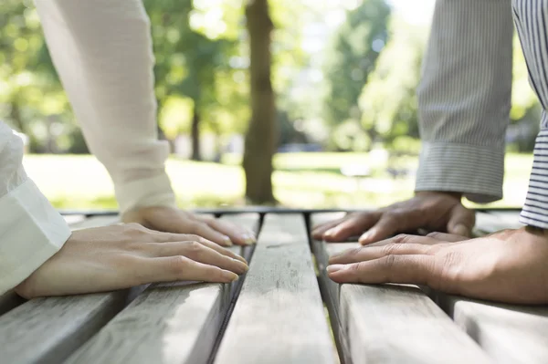 Homem e mulher sentam-se em uma mesa com as mãos . — Fotografia de Stock
