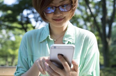 Mavi gömlekli genç kadın yakın çekim yakışıklı cep telefonu mesajı okur