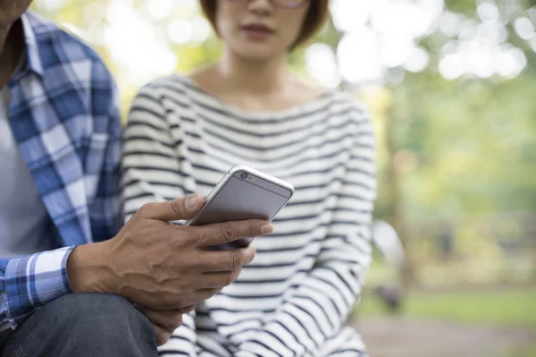 Grupo de amigos sonrientes con smartphone en el parque Imagen de stock