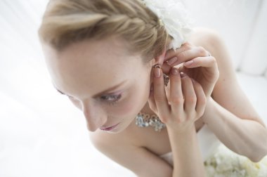 Güzel esmer, şık gelin sabah odada hazırlanıyor.