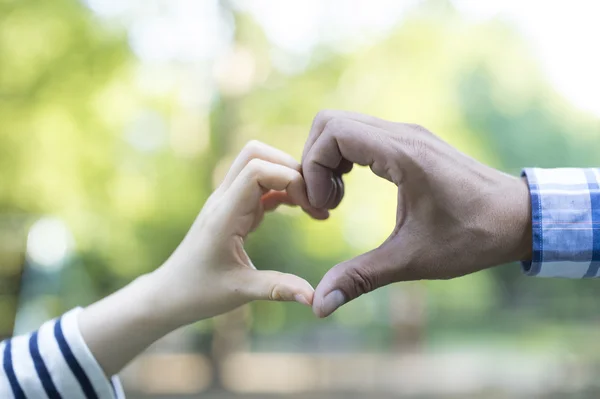 Mooie jonge paar maken van hart met handen — Stockfoto