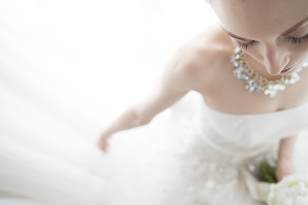 Wedding bouquet of white roses in the hands of the bride