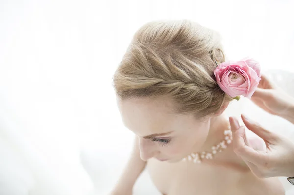 Stylist to put a corsage on bride Royalty Free Stock Images