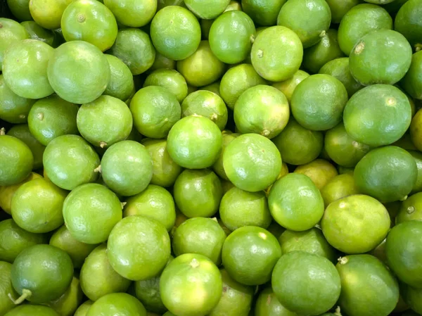 Yüksek açılı, yeşil limon (Citrus aurantifolia) bir süpermarkette istiflenmiş, Tayland.