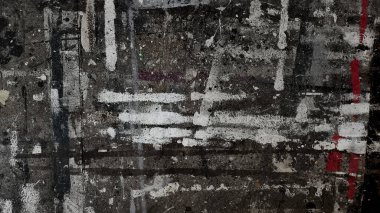 Urban textured surface street or wall heavily layered with dirty, abstract paint splatters and streaks. Dark gray background with muticolored lines