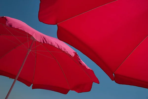 Nahaufnahme Zweier Roter Sonnenschirme Von Unten Blauer Himmel Hintergrund Sonniger — Stockfoto