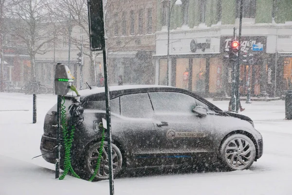 Elektrikli araba şarj istasyonuna bağlandı. Kış ve karlı hava. Trondheim, Norveç.