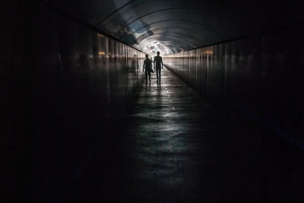 Light in the end of the tunnel. A couple in silhouette. Copy space. Blurred and sharp areas.