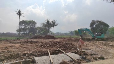 Cikancung, Batı Java, Endonezya - 14 Haziran 2021: Zemini yerle bir eden bir kazıcının bulunduğu inşaat alanının fotoğrafı