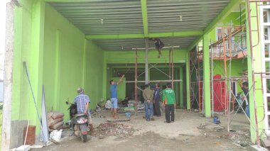 Cikancung, Batı Java, Endonezya - 19 Haziran 2021: Çatıların ve zeminin onarımını izleyen vatandaşların fotoğrafı