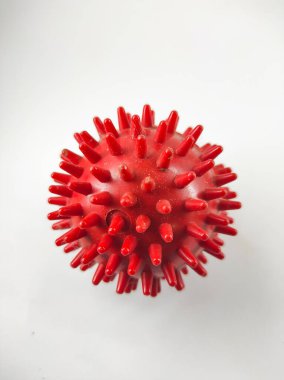 Photo of red rubber ball with full of thorns isolated on white background in mini studio