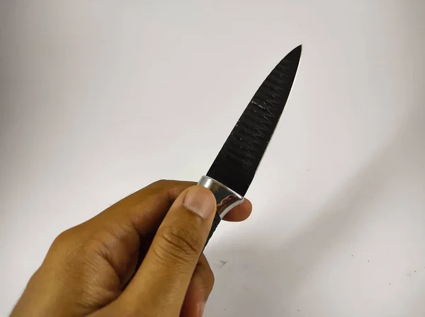 Foto Una Mano Sosteniendo Pequeño Cuchillo Negro Aislado Sobre Fondo — Foto de Stock