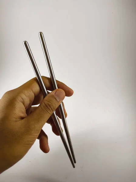 Abstract Defocused Photo Hand Holding Metal Chopsticks Isolated White Background — Φωτογραφία Αρχείου