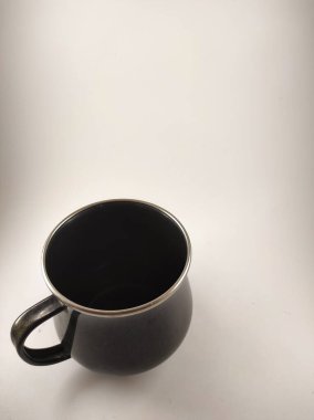 Beyaz arkaplanda izole edilmiş boş siyah kupanın fotoğrafı