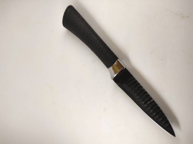Beyaz arka planda izole edilmiş küçük siyah bir bıçağın odaklanmış fotoğrafı.