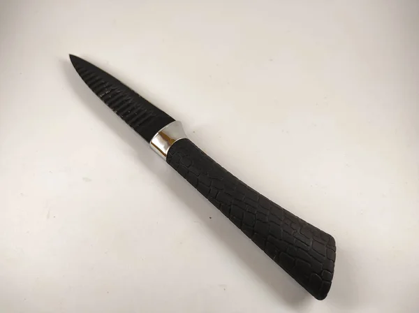 Abstraktes Defokussiertes Foto Eines Kleinen Schwarzen Messers Isoliert Auf Weißem — Stockfoto