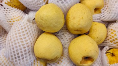 Photo of a pile of pears packed in nets and sold in supermarkets