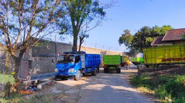 Cikancung, Batı Java, Endonezya - 14 Ağustos 2021: Dar bir yolda park edilmiş malları taşıyan çok sayıda kamyonun fotoğrafı