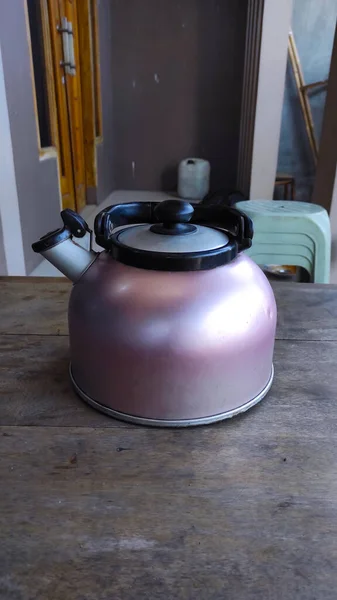 照片上是一个茶壶 茶壶里放满了热茶 放在木桌上 — 图库照片