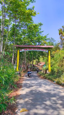 Cikancung, Batı Java, Endonezya - 26 Ağustos 2021: Bir tepenin üzerindeki ve ormanla çevrili Cikancung köyünün kapısının fotoğrafları