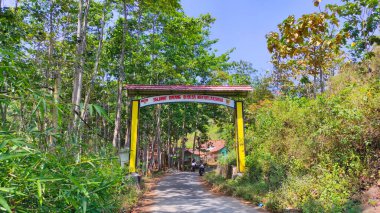 Cikancung, Batı Java, Endonezya - 26 Ağustos 2021: Bir tepenin üzerindeki ve ormanla çevrili Cikancung köyünün kapısının fotoğrafları