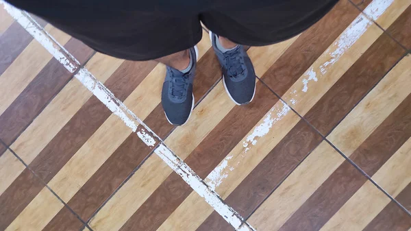 要約は バドミントンコート上のラインパターンを持つ床の上の足の写真を集中 — ストック写真