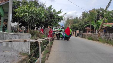 Cikancung, West Java, Endonezya - 14 Eylül 2021: Otoyol kenarında bir sebze satıcısının etrafında toplanan çok sayıda kadının soyutlanmış fotoğrafı