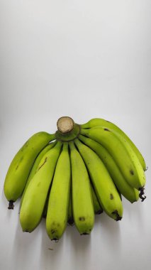 Beyaz arka planda izole edilmiş bir grup yeşil muzun odaksız fotoğrafı.