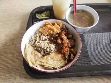 Yakın plan Çin-Endonezya eriştesi baharatlı tavuk, baharatlı sığır eti yağlı et, wonton krakeri ve bir kase et suyu. Müşteriler için ana yemek..