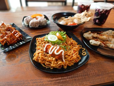 Baharatlı erişteler, biberli yağlı börekler, şiş balıklı kekler, karidesli börekler ve iki bardak soğuk içecek. Masada ziyafet