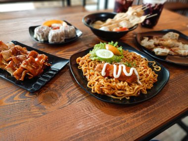 Baharatlı erişteler, biberli yağlı börekler, şiş balıklı kekler, karidesli börekler ve iki bardak soğuk içecek. Masada ziyafet