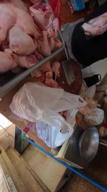 Bir kasabın dükkanından tavuk alırken dikey bir bakış açısı. Geleneksel bir pazarda 4K HD çözünürlükte alışveriş görüntüleri.