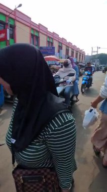Bandung, Endonezya. 6 Şubat 2026. Dikey FPV video klip motosikletler park edilmiş ve geleneksel bir pazar alanının önünden geçiyor. Geleneksel bir pazarın açık hava alanının POV görüntüleri.