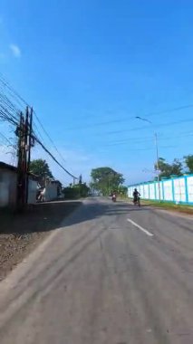 Bandung, Endonezya. 4 Şubat 2026. Güneşli bir sabahta bir otoyolda kamyon ve motosikletlerin yanından geçerken çekilmiş dikey FPV videosu. 4k HD çözünürlükte motosiklet sürerken POV görüntüleri.
