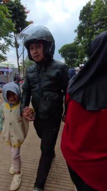 Bandung, Endonezya. 15 Şubat 2026. Pazar sabahı Bandung Tepesi 'nin tepesinde ziyaretçi ve sokak satıcılarıyla dolu bir yolun dikey videosu. Tatillerde yoğun Puncak bölgesinin POV görüntüleri.