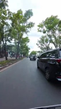 Bandung, Endonezya. 11 Şubat 2026. Bandung 'un kentsel sokaklarının birinci şahıs görüntüsünün sinematik dikey videosu. 4K HD çözünürlüklü bir şehir caddesinde motosiklet sürerken POV görüntüleri.