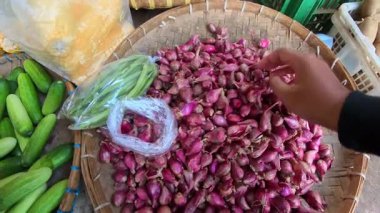Birinci şahıs POV, Bandung, Endonezya 'da geleneksel bir pazarda bambu tepsiler üzerinde küçük çiğ arpacık soğanları seçiyor. POV 4K Kararı 'nda geleneksel bir pazardan alışveriş görüntüsü